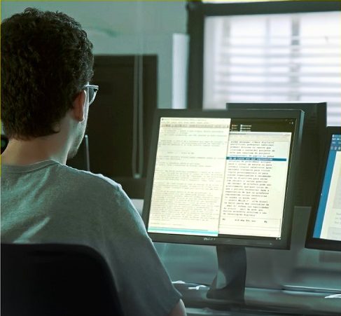 Imagem de uma pessoa de costas acessando o computador.